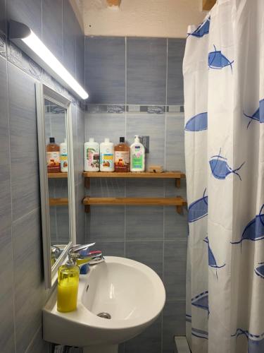 a bathroom with a sink and a shower curtain at The Light Blue House in Karavostamo