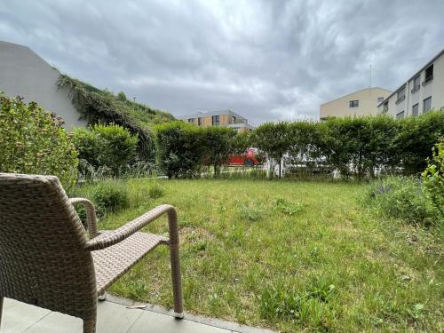 a wicker chair sitting in a field of grass at Hotel Panská Zahrada in Dobřichovice