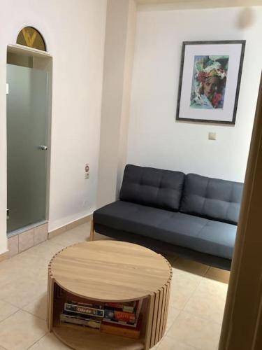 a living room with a blue couch and a table at Lemon tree in Filiatra