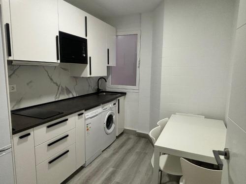 a kitchen with white cabinets and a washer and dryer at Céntrico apartamento reformado de dos habitaciones in Logroño