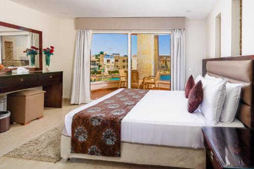 a bedroom with a bed and a desk and a balcony at Seagull Beach Resort - Families and Couples Only in Hurghada