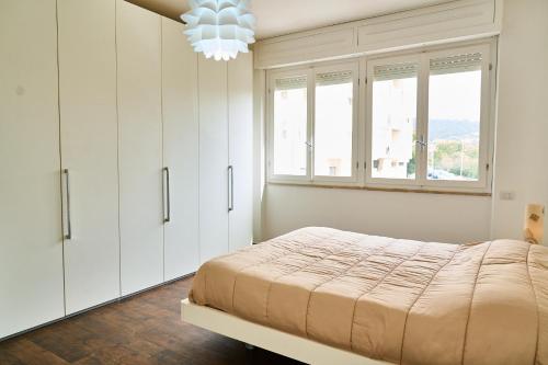 Schlafzimmer mit einem Bett mit weißen Schränken und einem Kronleuchter in der Unterkunft Casa Rosita in Carbonia