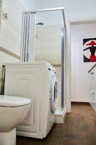 a white bathroom with a toilet and a washing machine at Casa Rosita Spazio Comfort e Relax 130mq con 3 Camere in Carbonia