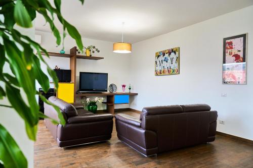 a living room with two leather chairs and a television at Casa Rosita Spazio Comfort e Relax 130mq con 3 Camere in Carbonia