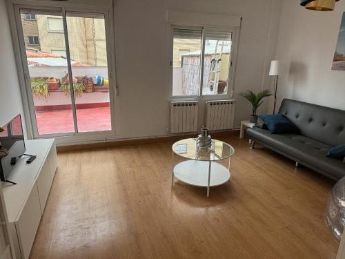 a living room with a couch and a glass table at Céntrico apartamento reformado de dos habitaciones in Logroño