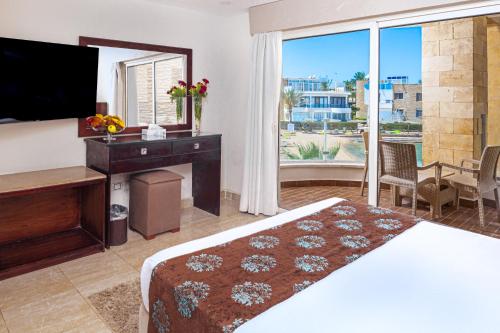 a bedroom with a bed and a desk and a mirror at Seagull Beach Resort - Families and Couples Only in Hurghada