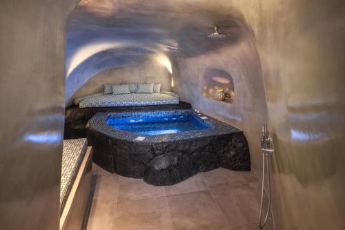 a room with a bath tub in a cave at Elia 2 bedroom cavehouse with indoor jacuzzi in Vóthon