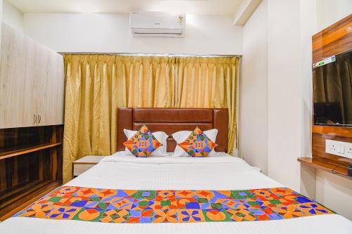 um quarto com uma cama com um edredão colorido em FabHotel The Luxurie International em kolkata