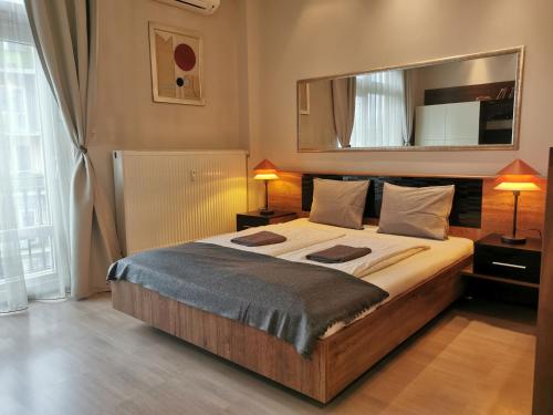 een slaapkamer met een groot bed en een grote spiegel bij Jackquaters in Boedapest