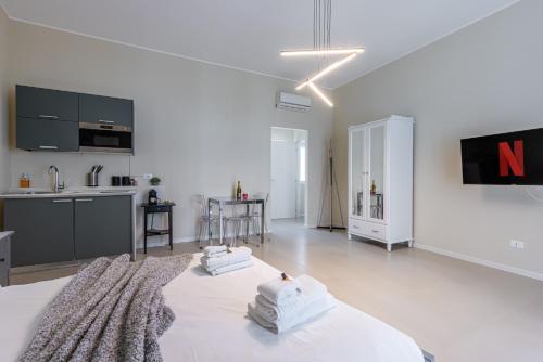 a white living room with a large bed and a kitchen at Boccaccio's Flats in Milan