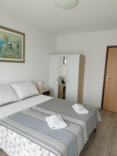 a bedroom with a bed with two towels on it at ApartmanA&J1111 in Kaštela