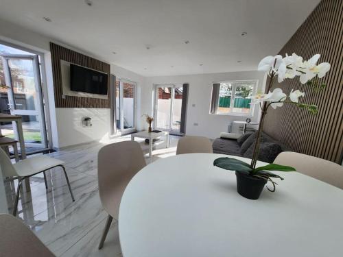 a white dining room with a white table and chairs at Spacious and bright one bedroom apartment in Oxford