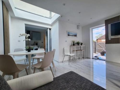 Una sala de estar blanca con una mesa y sillas. en Spacious and bright one bedroom apartment, en Oxford