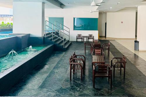a room with tables and chairs and a swimming pool at Comfy-Concept Apartment @ B.Bintang (3min walk LRT, Lalaport, TimeSquare) in Kuala Lumpur
