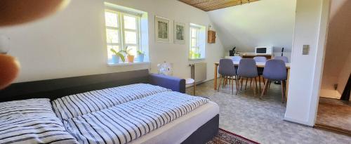 een slaapkamer met een bed en een eetkamer bij Quiet and cozy apartment close to nature in villa. in Tilst