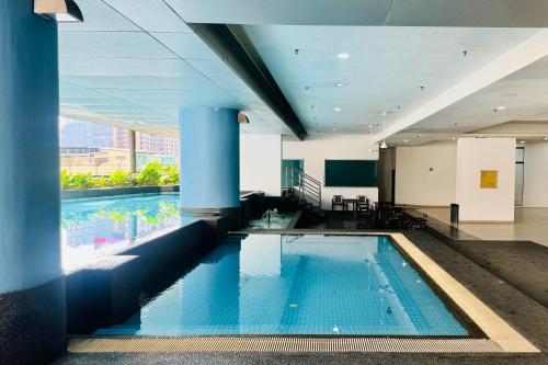 - une grande piscine dans un bâtiment doté d'une grande fenêtre dans l'établissement Comfy-Concept Apartment @ B.Bintang (3min walk LRT, Lalaport, TimeSquare), à Kuala Lumpur