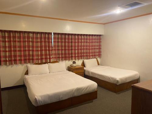 a hotel room with two beds and a window at Tzu Chi Hotel in Pingtung City