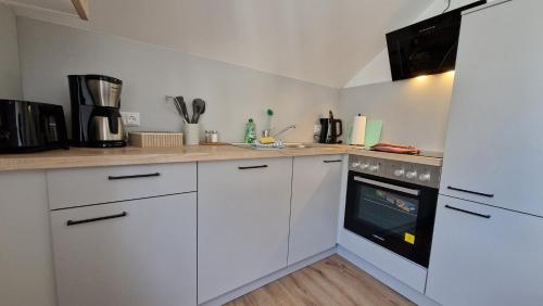 a kitchen with white cabinets and an oven at Ferienwohnung Millstatt in Millstatt