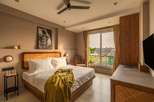 a bedroom with a bed and a large window at Minimalist Panjim in Marmagao
