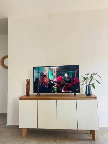 a television on a white cabinet in a living room at Appartement meublé en plein centre-ville de Diego Suarez in Diego Suarez