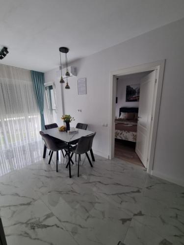 una sala da pranzo con tavolo e sedie e una camera da letto di Roxana Residence a Oradea