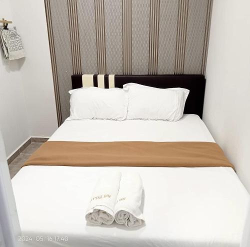 ein Schlafzimmer mit einem Bett mit zwei Handtüchern darauf in der Unterkunft Rayyaz Inn in Kuala Terengganu