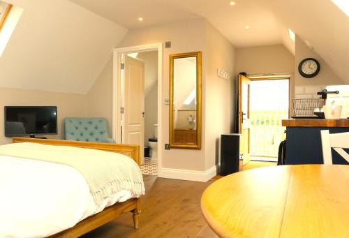 um quarto com uma cama, uma mesa e uma televisão em The Loft at the Croft - Stunning rural retreat perfect for couples & dogs em Leigh
