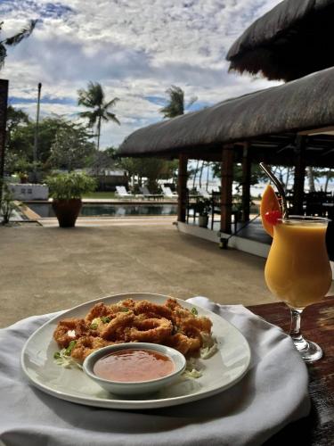 a plate of food on a table with a drink at The Ananyana Beach Resort by SMS Hospitality in Panglao