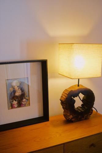 a lamp on a dresser next to a mirror at Casa Oliva - Casa da Lenha in Porto de Mós