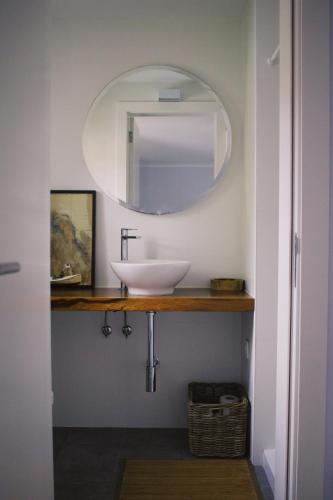 a bathroom with a sink and a mirror at Casa Oliva - Casa da Lenha in Porto de Mós