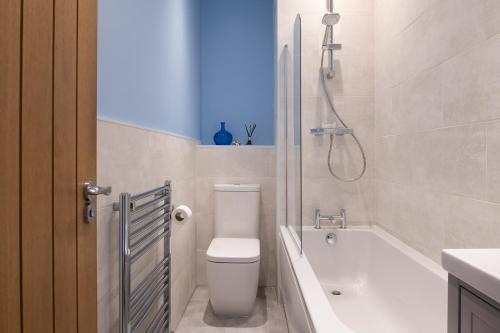 uma casa de banho com um WC, uma banheira e um chuveiro em Abbey Road Boutique Holiday Apartment em Llandudno