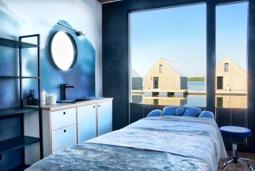 1 dormitorio con cama, lavabo y espejo en Domy na Wodzie na Mazurach en Pisz