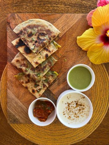 a plate of food with a plate of bread and dipping sauces at Aura Boutique Hotel in Udaipur