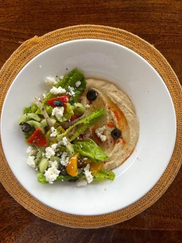 a white bowl of food with a taco and a salad at Aura Boutique Hotel in Udaipur