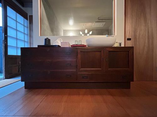 松山市にあるグループに最適The Bath & Bed Dogo 築110年の蔵をリノベした源泉掛け流し一棟貸しの温泉宿のバスルーム(鏡付きの木製ドレッサー付)