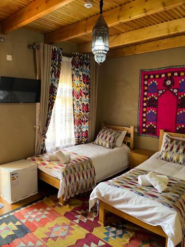 - une chambre avec 2 lits et un lustre dans l'établissement Old Palace Hotel, à Samarcande