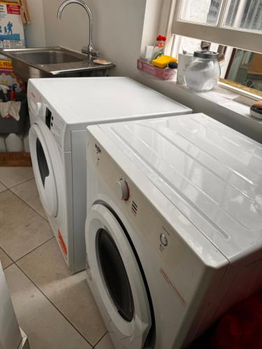 a washer and dryer in a kitchen next to a sink at Not very Quiet but best location in London