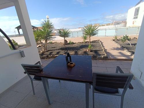 einen blauen Tisch und Stühle auf einer Terrasse mit Strand in der Unterkunft Apartamento SUN Complex Amaya Fuerteventura in Costa de Antigua