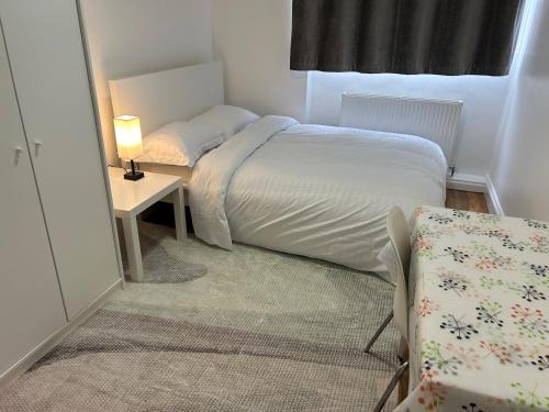 a small bedroom with a bed and a table and a chair at London City Inn Stepney in London