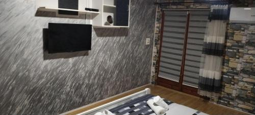 a bathroom with a shower and a wall with a shower at Sobe Lara in Donji Milanovac