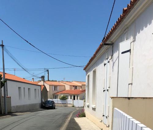 une rue vide dans une ville avec des bâtiments blancs dans l'établissement 3 Bedroom Les Sables D'Olonne House, à Olonne-sur-Mer