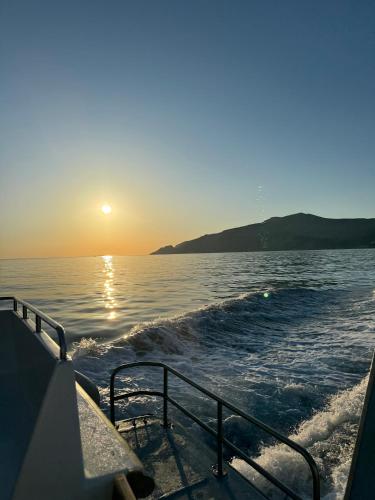 a boat in the water as the sun sets at Hydra's View in Hydra