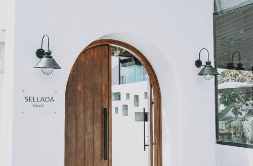 an arch shaped mirror on a wall with two lights at Sellada Beach in Perissa