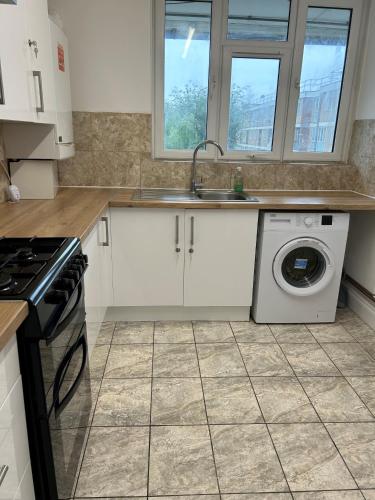 a kitchen with a sink and a washing machine at London City Inn Stepney in London