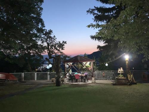 a gazebo with a table in a yard at night at Melnicani, Breathtaking view in Debar