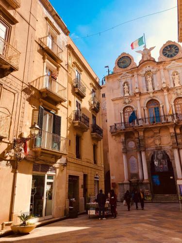 a group of people walking down a street next to buildings at Casa Garibaldi in Trapani