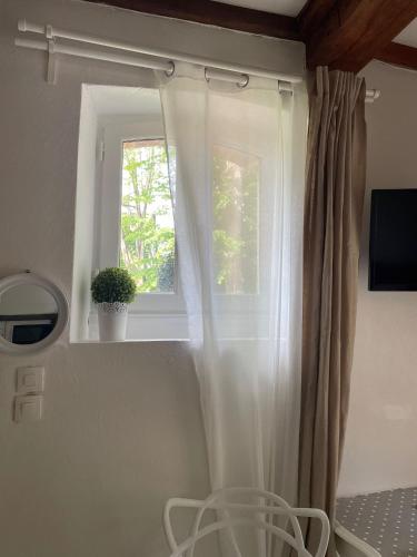 - une fenêtre avec un rideau blanc dans la chambre dans l'établissement Halte entre Terre et Mer à Bayeux, à Bayeux