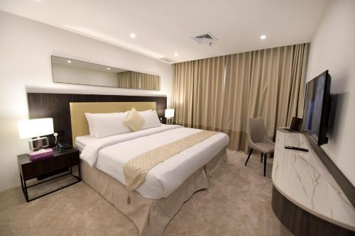 فندق الكويت كارلتون تاور في الكويت: غرفه فندقيه سرير كبير وتلفزيون