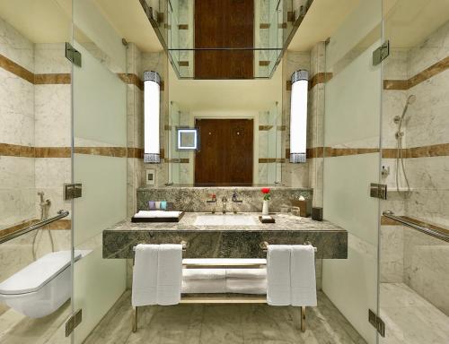 a bathroom with a large sink and a toilet at Conrad Makkah in Makkah
