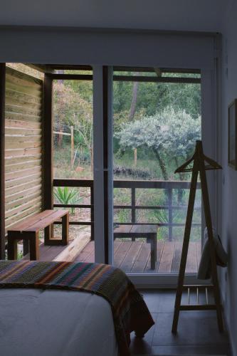a bedroom with a bed and a view of a porch at Casa Oliva - Casa do Lago in Porto de Mós
